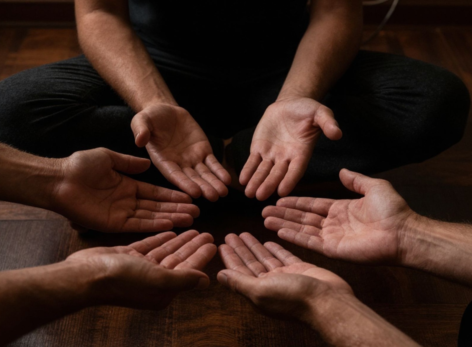 Angebote für Männer: Nahaufnahme von mehreren Männerhänden in einer Tantra-Massage zur achtsamen Körperarbeit.