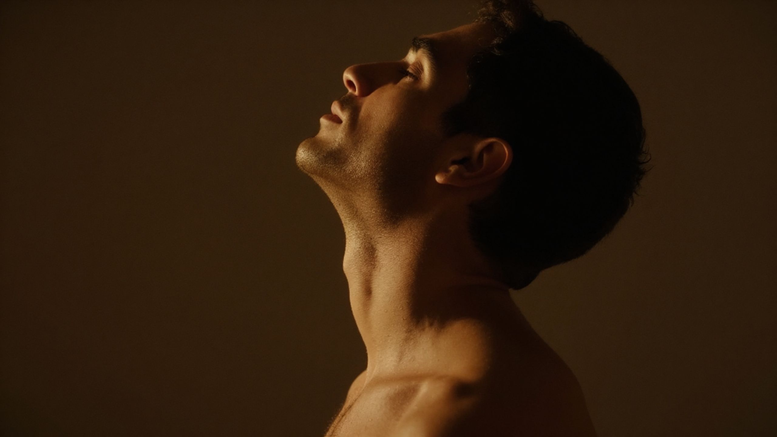 Als Symbolbild für entspannte Ratenzahlung für die Ausbildung zum Tantra-Masseur ein seitliches Portrait eines Mannes in warmem Licht.